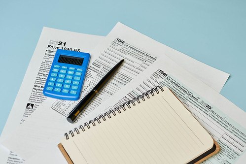tax forms on a table with a notebook and calculator