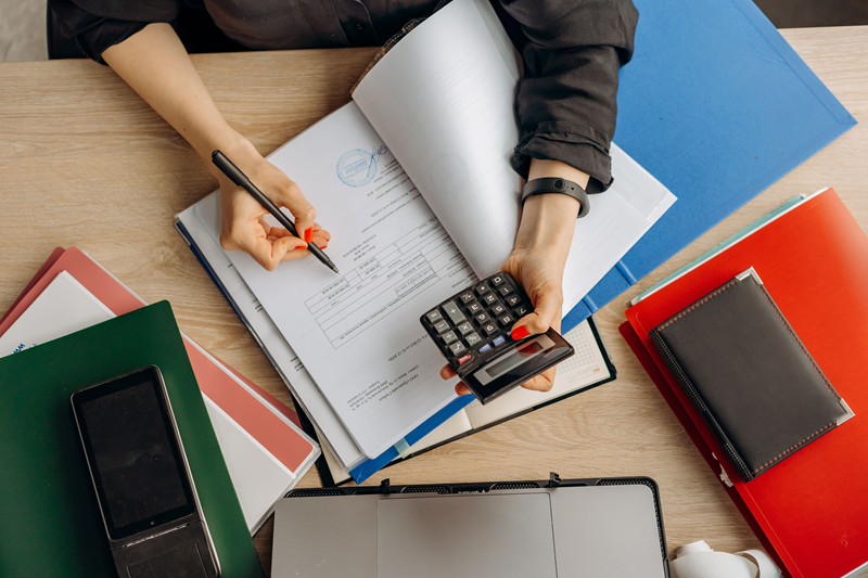 Business owner working on taxes with calculator and documents